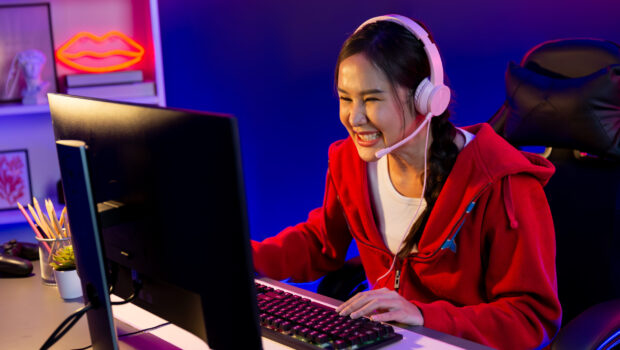 Host channel Asian streamer concentrating game wearing headphone. Stratagem.